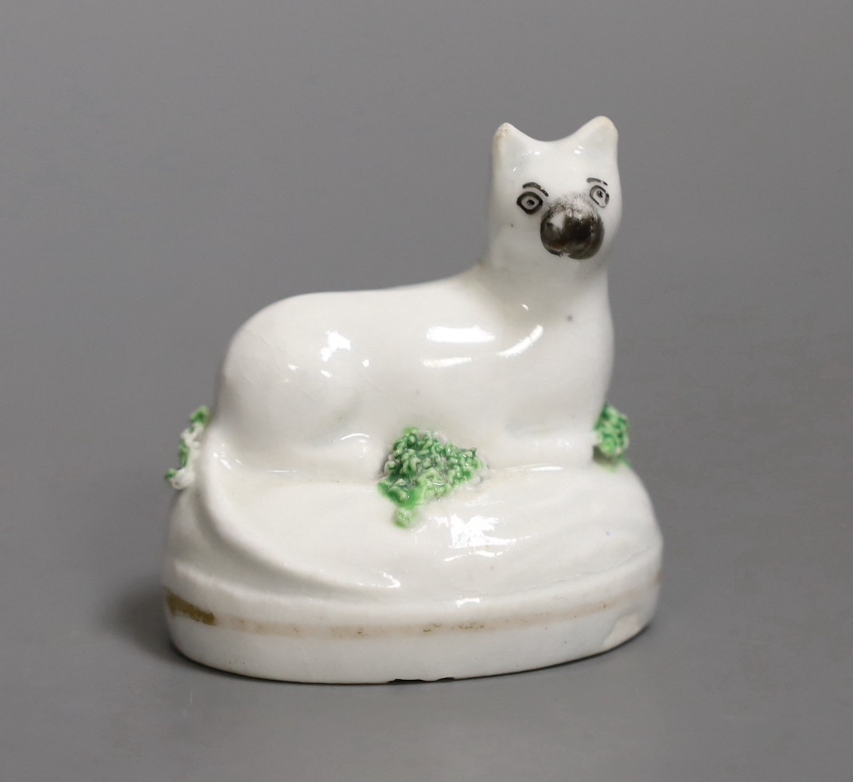 A rare Staffordshire porcelain figure of a recumbent cat, c.1830-50, 4.7cm, Not recorded in Dennis G.Rice, Cats in English porcelain., Provenance: Dennis G.Rice collection